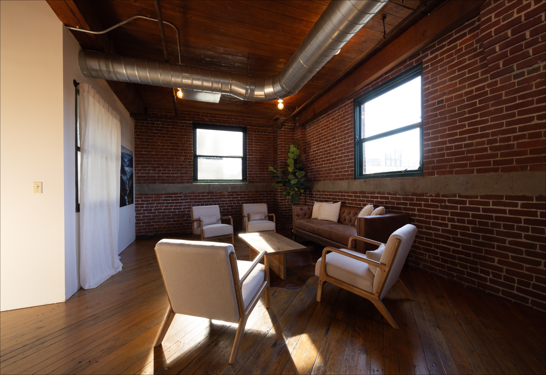 Individual Experience 6 Cozy retreat space with brick walls, wooden floors, and comfortable seating, showcasing a welcoming environment for the women's only retreat at Experience Onward.