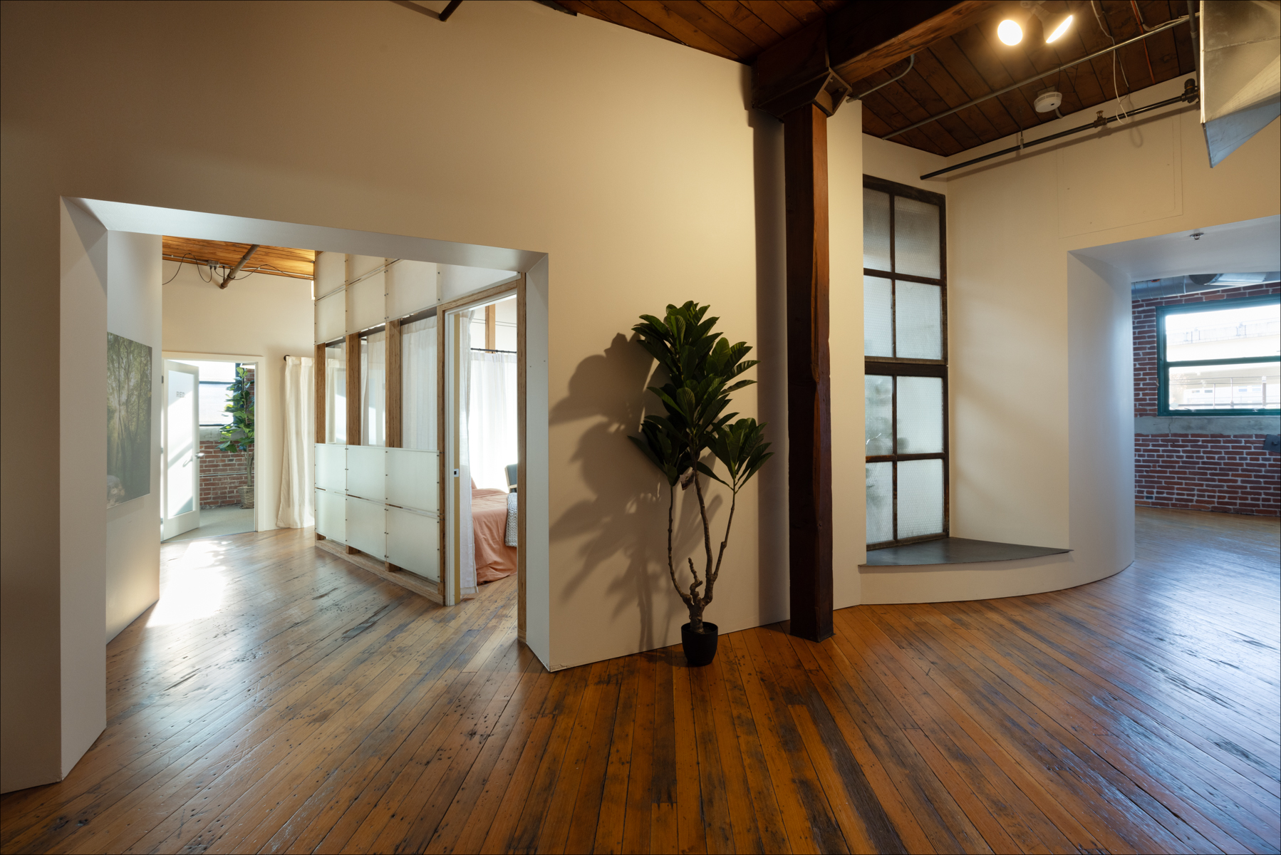 Individual Experience 2 Spacious interior of a healing center with wooden floors, plants, and natural light, reflecting a comfortable environment for a women's only retreat.