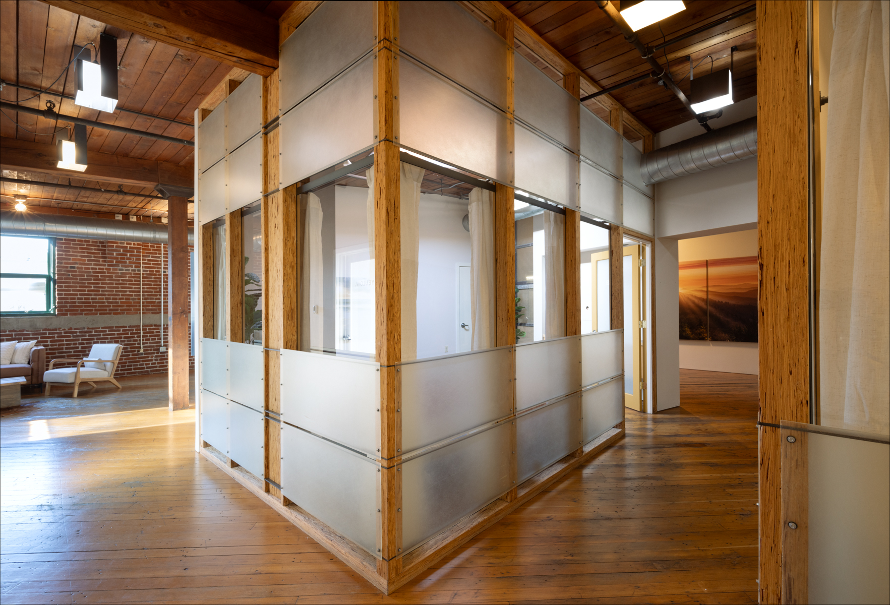 Individual Experience 7 Modern interior of a healing retreat center featuring a glass-walled room with wooden accents, inviting natural light, and a cozy seating area.